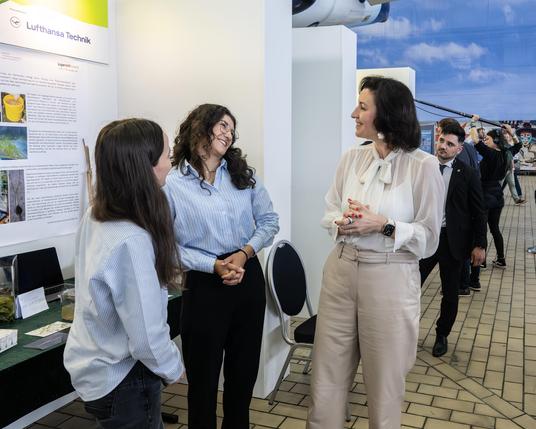 Am Präsentationsstand des Projekts: "Studie zur Gewinnung von Rohrkolbensaat und zur Anzucht für die Wiedervernässung von Mooren": Pia Pauline Bartel, Emely Müller, Bundesforschungsministerin Dorothee Bär (v.l.n.r.).