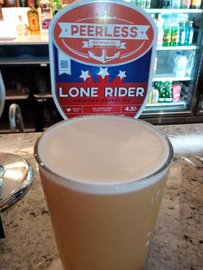 A pint of Peerless Brewing Lone Rider cask and its Pumpclip