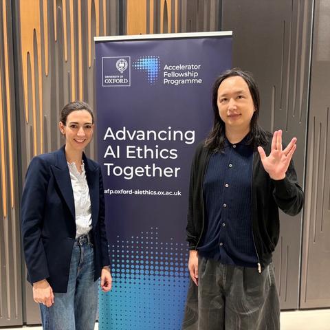 Audrey Tang stands beside Dr. Caroline Green, Director of Oxford’s Institute for AI Ethics, posing in front of a banner.