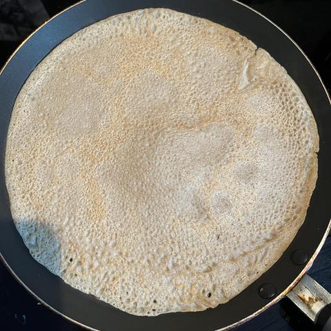 Eine Galettepfanne auf einem Herd, in der ein Galette backt…
