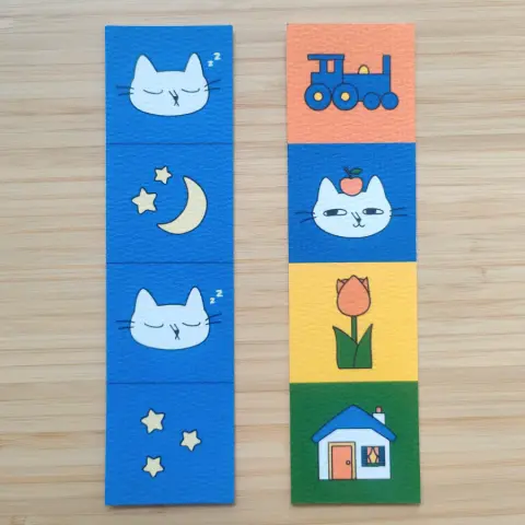 two colourful, handmade bookmarks with cats, houses, flowers and the night sky