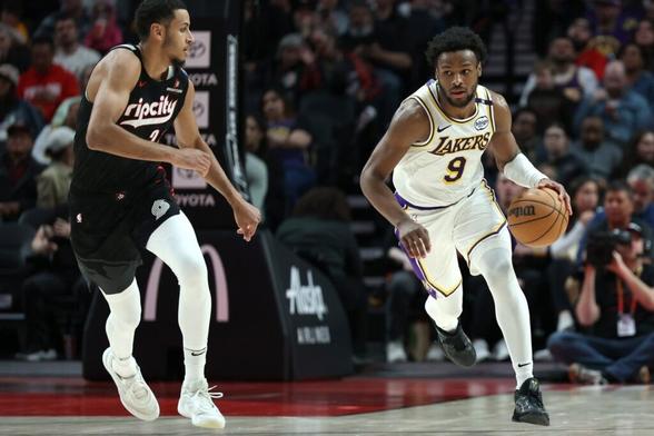 Apr 13, 2025; Portland, Oregon, USA; Los Angeles Lakers guard Bronny James (9) brings the ball up the court past Portland Trail Blazers forward Kris Murray (24) in the second half at Moda Center. Mandatory Credit: Jaime Valdez-Imagn Images