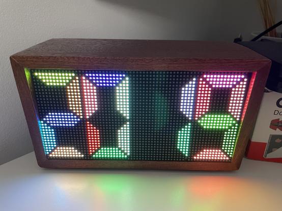 64 x 32 led panel in a mahogany box showing the time in a multicoloured segment 7 display