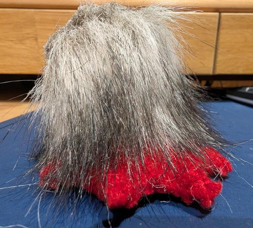A red foot with some black and white furry leg attached to it