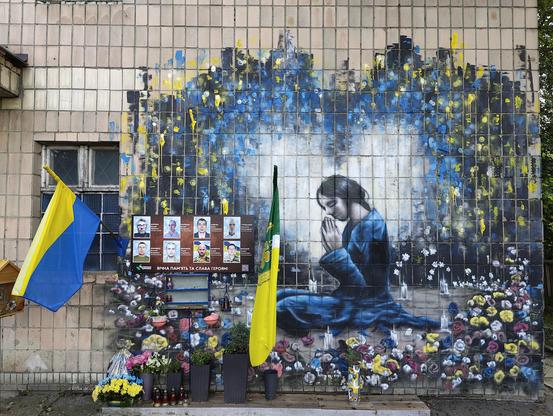 Ukrainian memorial eight executed people. Beautiful graffiti on the wall showing a girl praying.