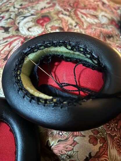 A blanket stitch going around the inner edge of a split earphone cover. The outer side already has two rows of blanket stitch.