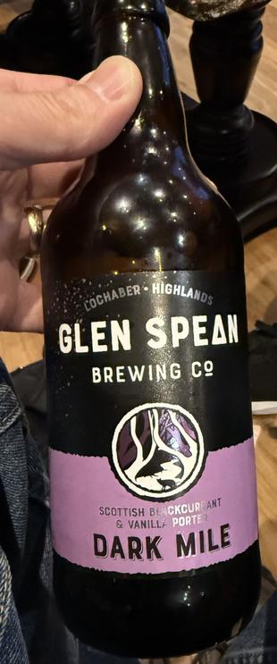 A brown pint bottle with a light purple and black label. The lettering is white and black