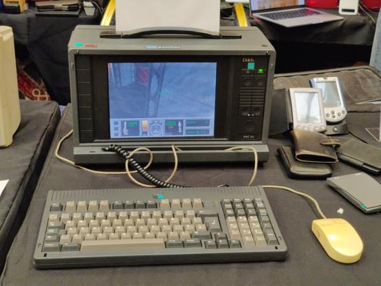 A front-on shot of the lunchbox. The screen is a tolerable colour TFT panel and the detachable keyboard is a compact layout with numpad and full-travel keys. The case is fetching grey with a black screen bezel.