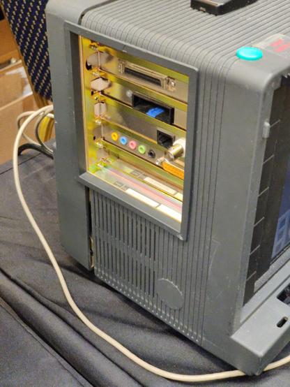 The left side of the lunchbox, showing a set of full-height cards. From top to bottom: external SCSI; a mystery slot that isn't PCMCIA, but much taller, with a blue tab on the lower lip; RJ-45 and coax network; audio card with yellow, blue, pink, green and black colour-coded 3.5mm jacks and a joystick connector. The lowest slot appears to be free, with a blanking plate in it.