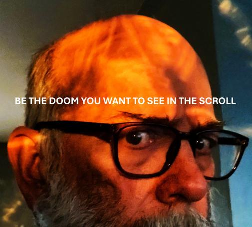 Tight cropped head selfie with horn rimmed glasses and a weird pattern of shadow and light on my bald head. Caption: BE THE DOOM YOU WANT TO SEE IN THE SCROLL
