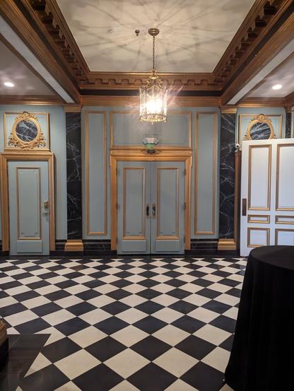 Old (art déco?) hotel hallway with checker floor. Dramatic shot of a large blue door