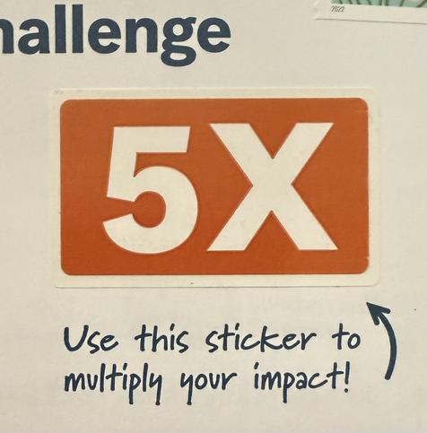 An envelope with the words “use this sticker to multiply your impact!” Printed on it, with an arrow pointing to a removable white on orange “5X” sticker above it.