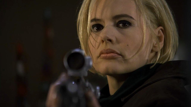 Charlie Baltimore looks motherfuckerly over the scope of a rifle she's pointing toward the viewer. Geena Davis in The Long Kiss Goodnight (1996)
