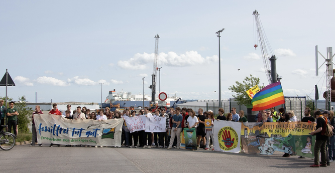 Demo gegen das LNG Terminal auf Rügen. Die Aktivist*innen stehen mit Plakaten und Transparenten vor dem Terminal.