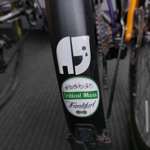 Makroaufnahme eines Schutzblechs mit den Aufklebern Natenom/Kagube mit weinendem Auge und "Critical Mass Frankfurt"