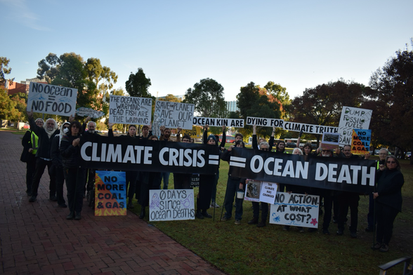 Group of demonstrators holding banners and signs with messages such as “CLIMATE CRISIS = OCEAN DEATH”