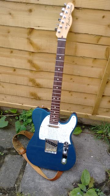 A picture of a lake placid blue fender telecaster with dark wood fingerboard and white pearl scratchplate