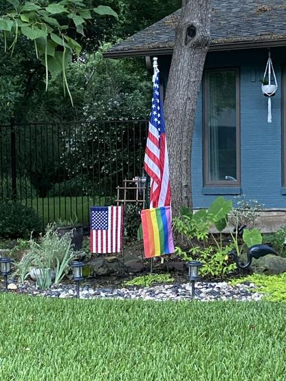 Two American flags. One large and one small. Next to it is a small pride flag.