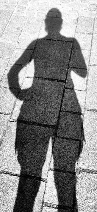 black and white photograph of my while body's shadow falling onto the street