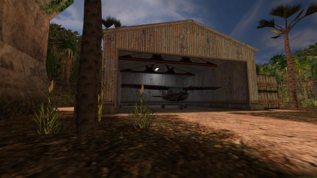 In this picture, from left to right, you can see a mountain, a tree, a hangar with a red and white Cessna inside, four large wooden boxes, two of which stand on top of the other two, and another tree. In the hangar you can also see a white illuminated lamp attached to the ceiling at the back, as well as two steel girders. Furthermore, there is a metal fence around the area in the background and behind it is a lot of jungle vegetation. This is on the map de_airstrip in the game Counter-Strike 1.6.