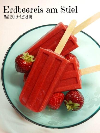 Grüne Glasschale, darin ein paar Erdbeeren und 3 Paletas- rote Eis am Stiel. Oben links steht in Druckschrift "Erdbeereis am Stiel".