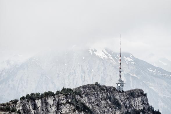 Niederhorn mit Sendeturm, dahinter der Niesen im Nebel.