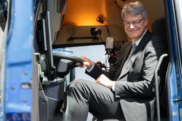 Patrick Schnieder sitzt im Fahrerraum eines Lkws und lächelt in die Kamera.