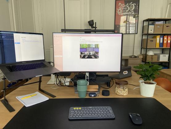 Photo of my work setup in my coworking space with a MacBook Pro, an external display, bluetooth keyboard, Apple Mouse and Screen lightbar