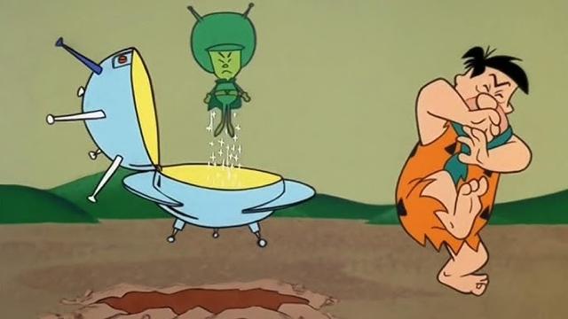 Fred Flintstone meets The Great Gazoo, a small green alien who flies.