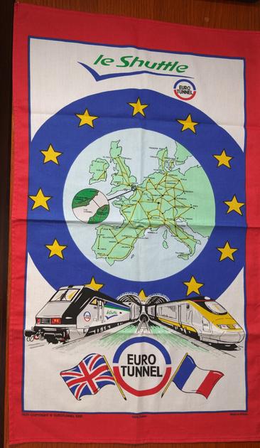 Tea Towel. 20x30in. Le Shuttle (euro tunnel)

EU Circle with 12 stars
Two trains, one 9012, one 3002, exiting the chunnel.
EuroTunnel logo (blue and red) on the bottom, UK flag on the left, France on the right

9630 
Copyright Eurotunnel 1995, 100% cotton, Made in Britain