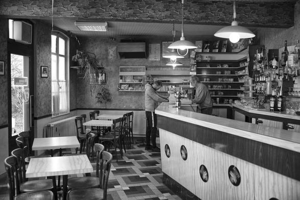 la salle principale du café de la gare où il y avait encore quelques cigarettes et un tout petit peu de presse