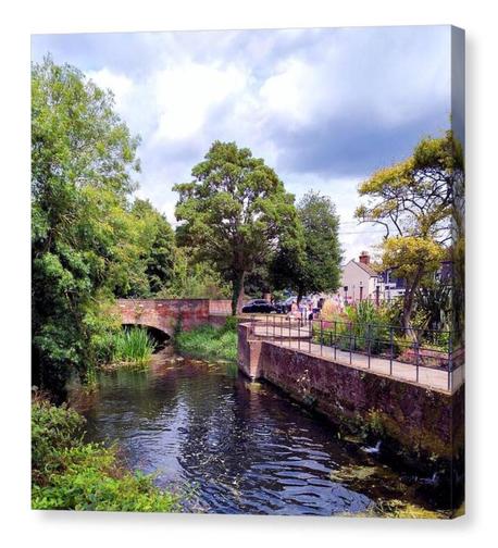 Square colour photograph showing an English park by a river on a warm sunny day.  The image is displayed upon a box canvas.