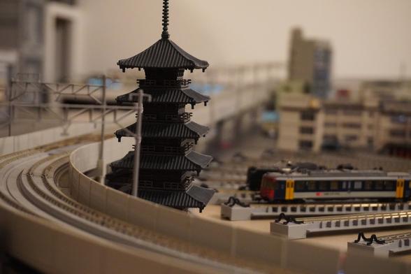 a 5 story high pagoda surrounded by rail track, richt next tonit is a turn tabke with some random engines on it.
rest of the city in the background