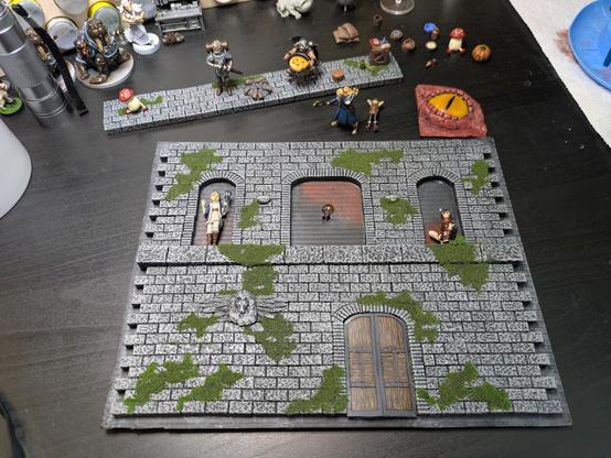 The back panel of the diorama sits in front of the bottom panel. Characters are starting to be glued to it, and a tiny LED is embedded in a blob of clear epoxy in the top middle window. The dragon eye will sit in front of it.