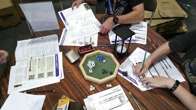 Photo of a gaming table with rulebooks and dice. The game is Tunnels and Trolls.