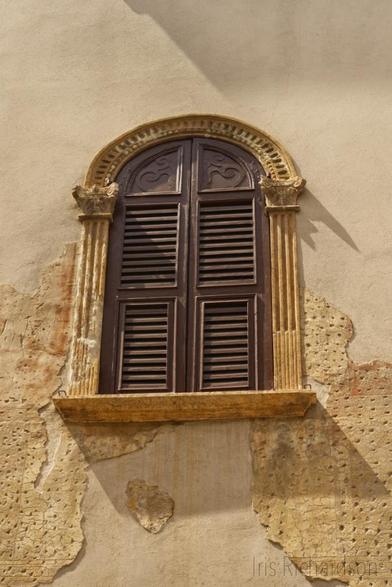 Dark brown windows with a golden yellow frame in Italy