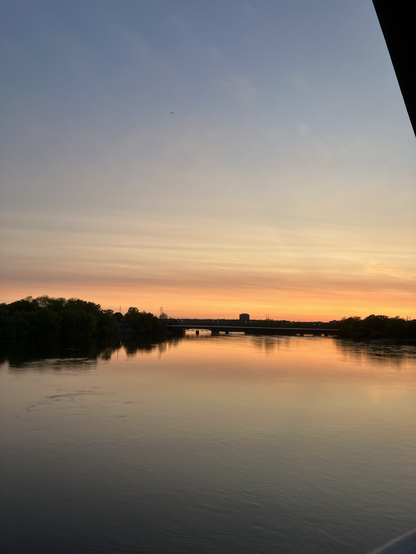 Sunset over the Ottawa River with trees and bridges midframe
