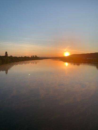 Kristinas Lieblingsstrecke über die Eisenbahnbrücke bei Konz mit schönem Sonnenaufgang: Mosel mit reflektierender Sonne.