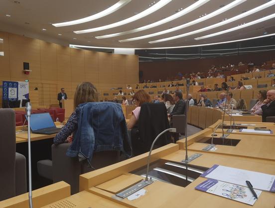 Grand amphithéâtre de l'hôtel de région des Hauts-de-France à Lille, plein de professionnels de santé et, sur la gauche, Hugo Gilardi au pupitre.