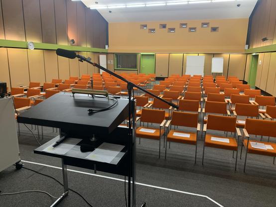 Leerer Konferenzraum mit orangefarbenen Stühlen.