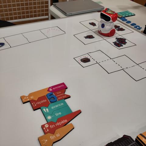 Photo d'une table blanche avec des morceaux colorés de blocs de code en bois.