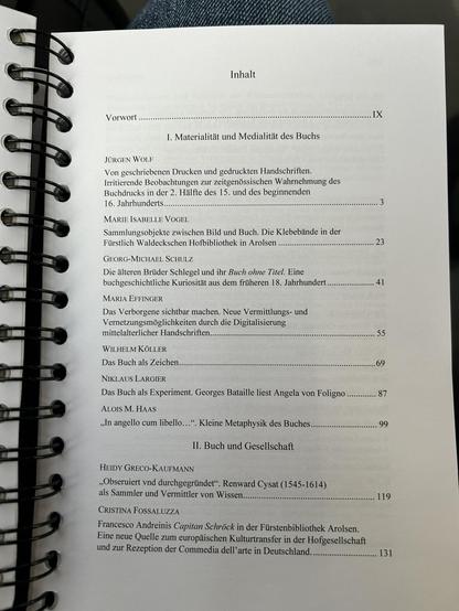 Inhaltsverzeichnis eines wissenschaftlichen Buchs in deutscher Sprache. Spiralgebundenes Dokument mit schwarzen Ringbindungen links sichtbar.
Inhalt
Vorwort (Seite IX)
I. Materialität und Medialität des Buchs

JÜRGEN WOLF: Von geschriebenen Drucken und gedruckten Handschriften. Irritierende Beobachtungen zur zeitgenössischen Wahrnehmung des Buchdrucks in der 2. Hälfte des 15. und des beginnenden 16. Jahrhunderts (S. 3)
MARIE ISABELLE VOGEL: Sammlungsobjekte zwischen Bild und Buch. Die Klebebände in der Fürstlich Waldeckschen Hofbibliothek in Arolsen (S. 23)
GEORG-MICHAEL SCHULZ: Die älteren Brüder Schlegel und ihr Buch ohne Titel. Eine buchgeschichtliche Kuriosität aus dem früheren 18. Jahrhundert (S. 41)
MARIA EFFINGER: Das Verborgene sichtbar machen. Neue Vermittlungs- und Vernetzungsmöglichkeiten durch die Digitalisierung mittelalterlicher Handschriften (S. 55)
WILHELM KÖLLER: Das Buch als Zeichen (S. 69)
NIKLAUS LARGIER: Das Buch als Experiment. Georges Bataille liest Angela von Foligno (S. 87)
ALOIS M. HAAS: "In angello cum libello...". Kleine Metaphysik des Buches (S. 99)

II. Buch und Gesellschaft

HEIDY GRECO-KAUFMANN: "Obseviert vnd durchgegründet" Renward Cysat (1545-1614) als Sammler und Vermittler von Wissen (S. 119)
CRISTINA FOSSALUZZA: Francesco Andreinis Capitan Schröck in der Fürstenbibliothek Arolsen. Eine neue Quelle zum europäischen Kulturtransfer in der Hofgesellschaft und zur Rezeption der Commedia dell'arte in Deutschland (S. 131)