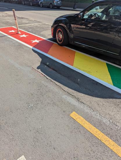 An indentation in the pavement in the middle of the bike lane, with the "cliff" parallel to the direction of travel, making it very dangerous for cyclists. There's a rad DC rainbow painted on the pavement next to the bike lane