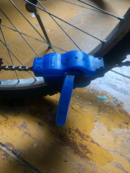 Szczotka do mycia łańcucha zapięta na nim. Niebieska