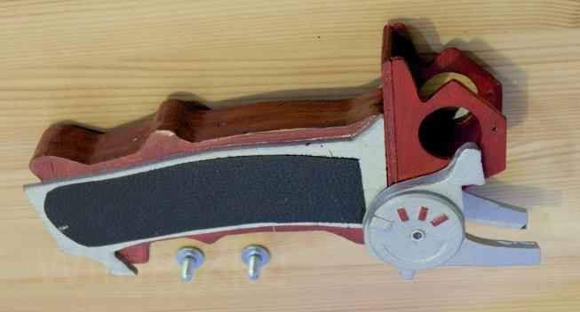 Ergonomic red handle with oddly shaped top and black leather piece on it