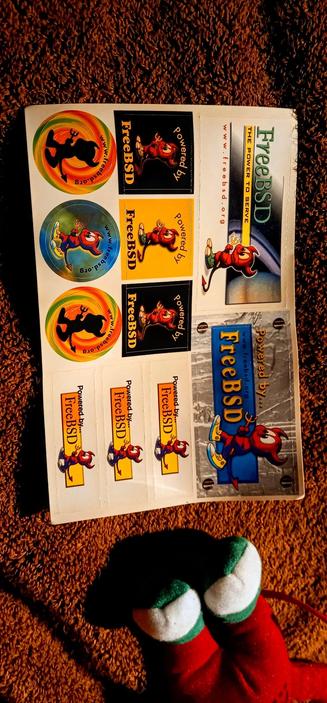 The photograph composed in absolute darkness shows a sheet of stickers laid out on a brown carpet. The stickers are related to freeBSD, a free and open-source operating system. The stickers feature a cartoon character resembling a red devil with antlers, wearing blue shoes and holding a pitchfork. The text "Powered by FreeBSD" is prominently displayed on several stickers, along with the website "www.freebsd.org." The stickers come in various designs, including circular logos with a colorful background and a silhouette of the character, rectangular labels with the character in different poses, and a larger sticker with the character on a blue background. The sheet also includes a larger sticker with the text "FreeBSD" and "The Power to Serve" on a gray background. The overall theme of the stickers is playful and colorful, with a focus on promoting the freeBSD operating system.

 Ovis2-8B

🌱 Energy used: 0.205 Wh