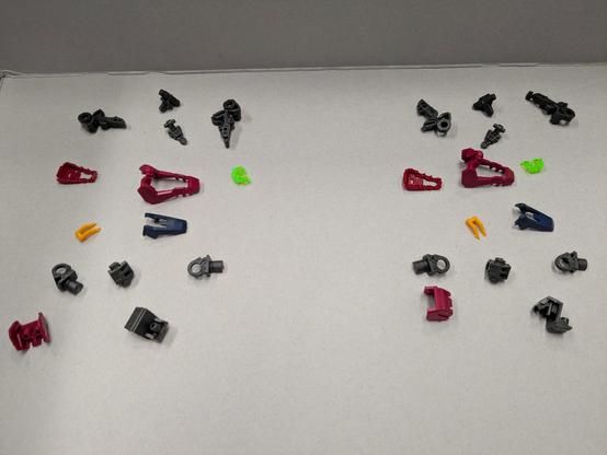 An assortment of red, gray, blue, yellow, and fluorescent green pieces that are intended to build the feet of the RG Gundam Epyon