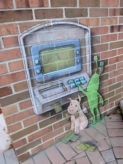 A chalk drawing of an ATM with a green alien pressing buttons and a winged pig eating the green dollars coming out of the cash dispenser
