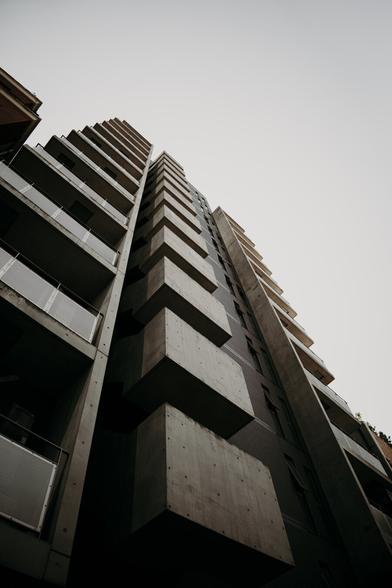 photo of a concrete building in Tokyo from below, showing the raw edges and lines of the architecture