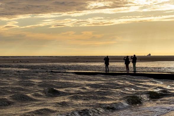 Fotografen am Strand fotografiere den Sonnenuntergang.